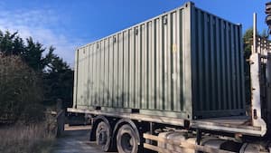 green container on back of HIAB lorry