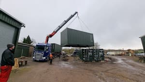 Wide image of unloading container from a lorry