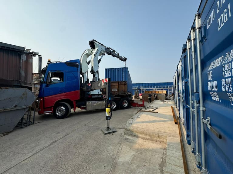 Shipping contaienr being delivered on a HIAB lorry